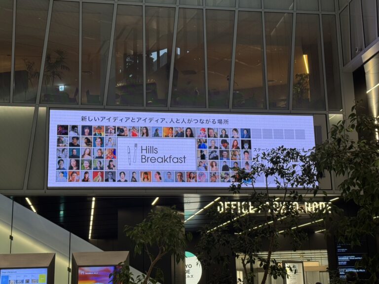 虎ノ門ヒルズのエントランスに設置された大型デジタルサイネージに、Hills Breakfastのイベント案内と多数の登壇者の写真が映し出されている様子。
