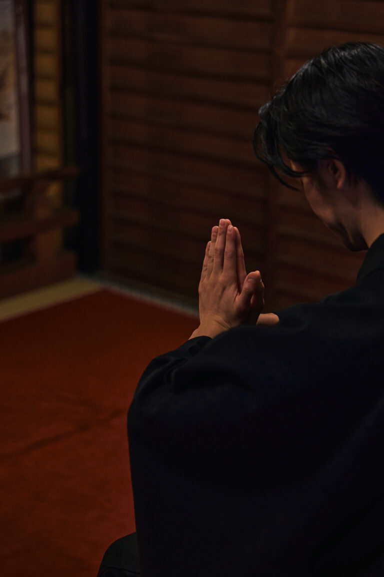 A Shinto priest performing a blessing in a quiet indoor setting