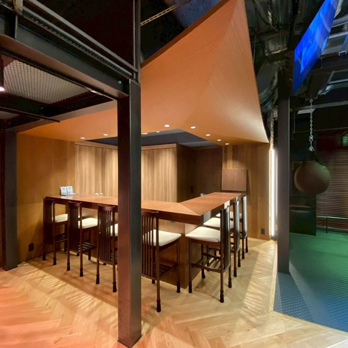 木目と間接照明でつくられた、バーのような雰囲気のカウンタースペース。チェアが並び、落ち着いた光が空間を照らしている。