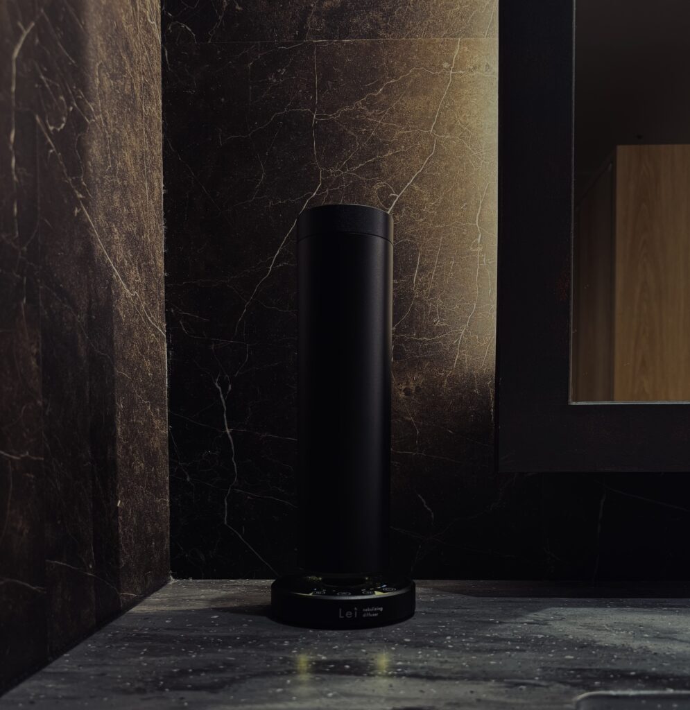 黒い大理石の空間に設置された、Leiの業務用アロマディフューザー。静かな光に包まれ、陰影の中で佇むように香りを放っている。