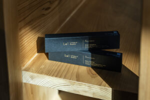 木の棚の上に、黒い箱に金文字が入ったLei Incense Collectionのパッケージ2箱が重ねて置かれている様子