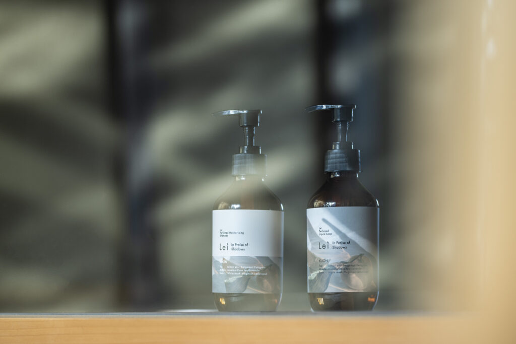 ガラス越しに並ぶ、Lei KUON Perfumed Moisturizing ShampooとPerfumed Liquid Soap（ポンプボトル）