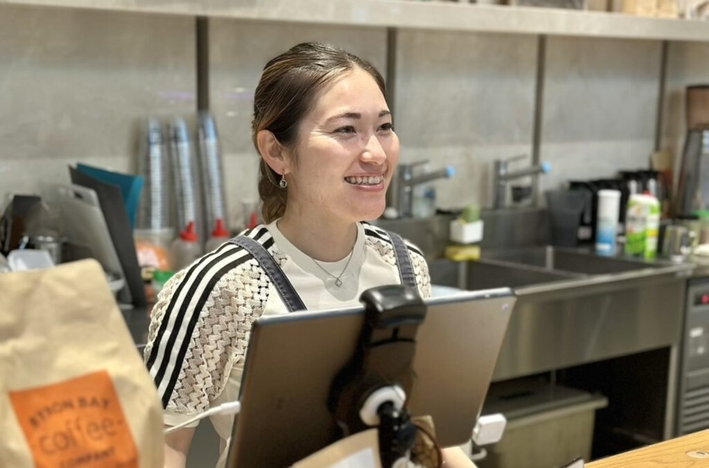 カフェのカウンターで笑顔を見せる元フィールドホッケー日本代表・永井葉月さん