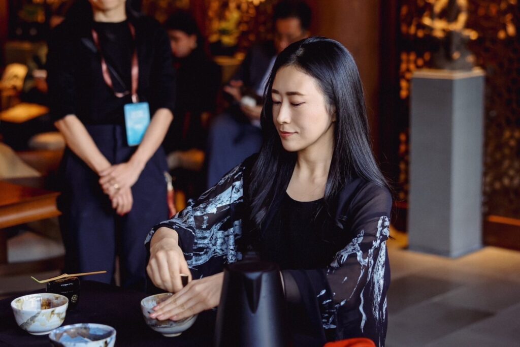 屋内で茶筅を使い、抹茶を点てる神山ナオミさん。お茶会での一場面