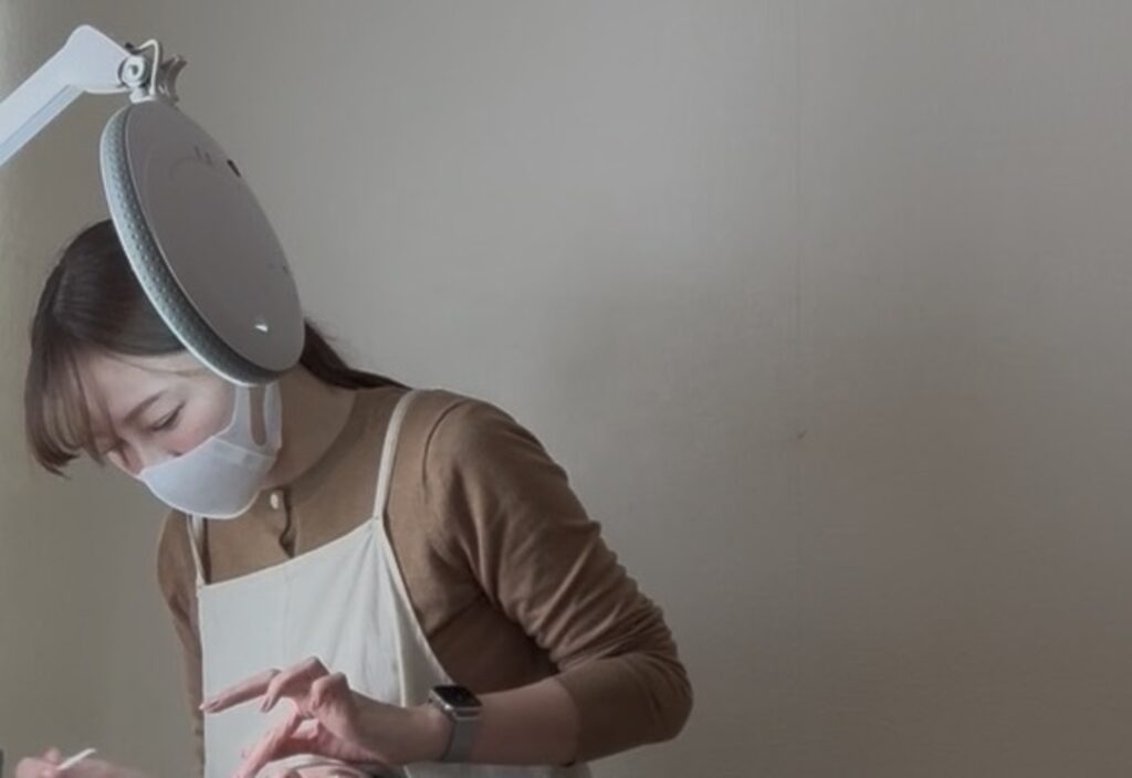 施術中の村瀬麻莉亜さん(マスク着用)の様子。手元に集中する横顔。