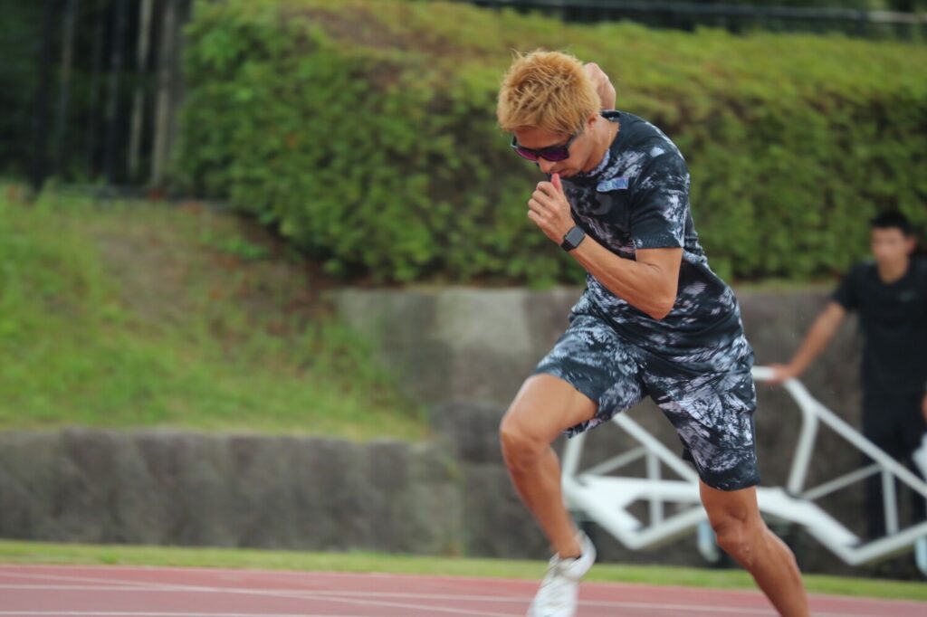 陸上トラックでスタートダッシュを切る藤光謙司さん。練習中の瞬間。