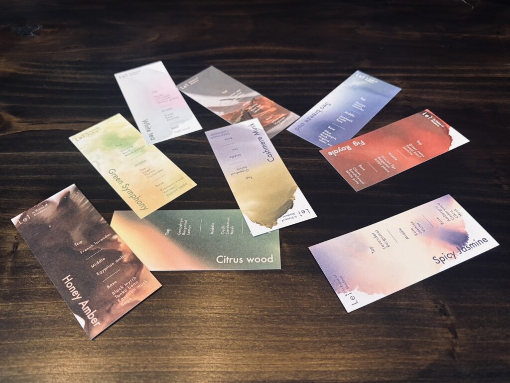 木目のテーブルの上に並べた、Leiの全9種の香りムエット（試香紙）デザイン。