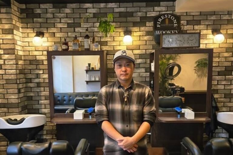 男性専用ヘアサロン「Barbiere」店内で、オーナー竹内稔さんが鏡の前に立つポートレート