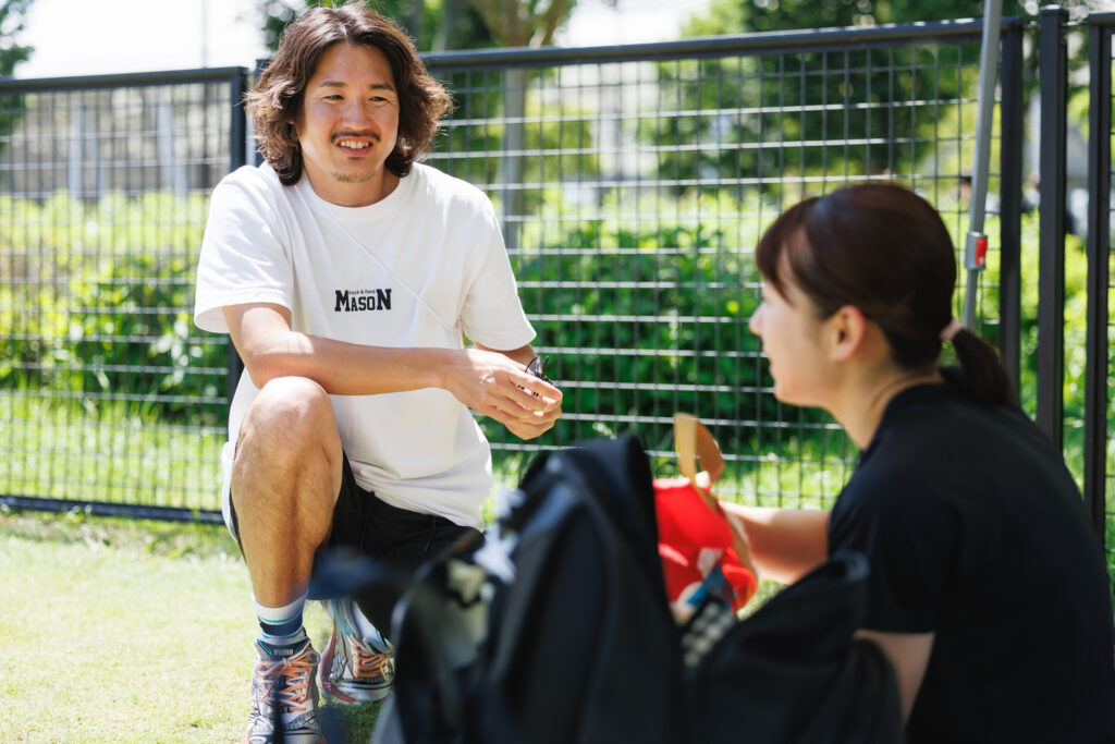 屋外で談笑する元陸上短距離走日本代表の小林雄一さん