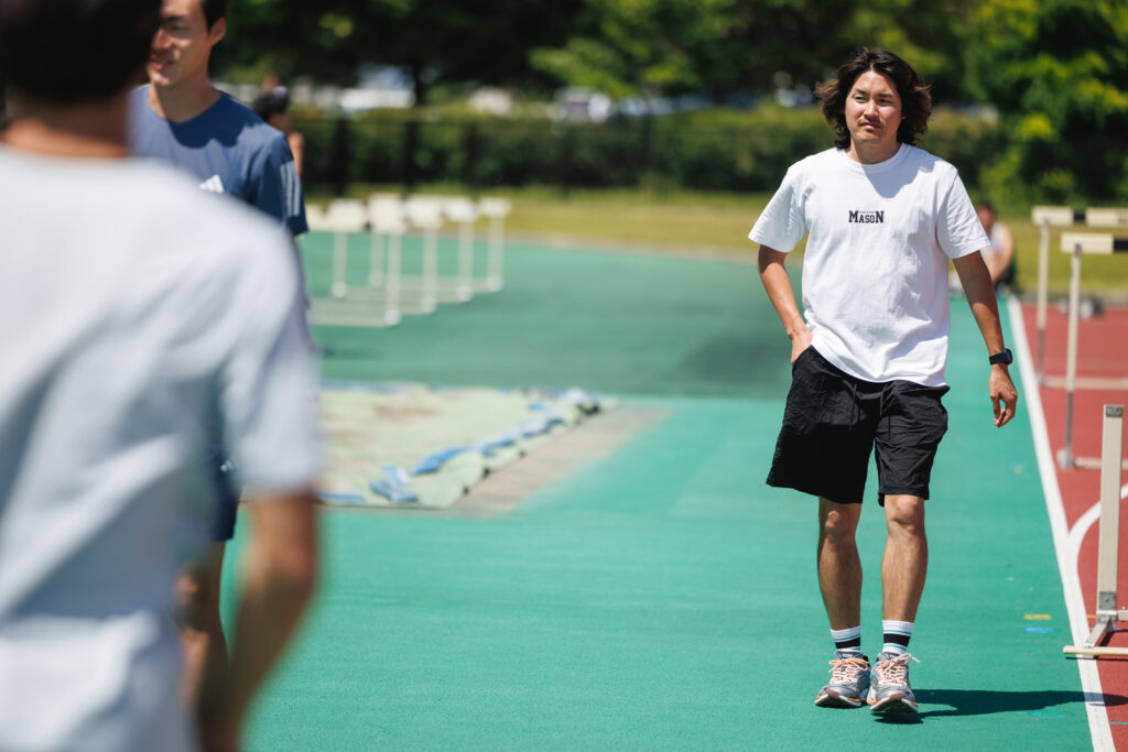 陸上競技場で歩く元陸上短距離走日本代表の小林雄一さん