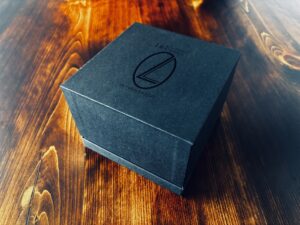 拭き漆を設えたテーブルに置かれたLei card diffuserの黒いギフトボックス（ロゴ入り）