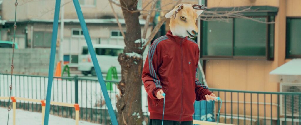 hayatoさんの映像作品ビジュアル。雪の残る公園で縄跳びを持ち、ヤギのマスクをかぶった人物が立つシーン