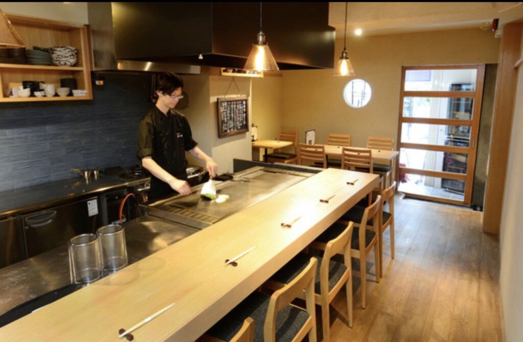 渋谷の鉄板焼き「澄み藤」店内のカウンター席と鉄板、調理中の須藤寛紀さん