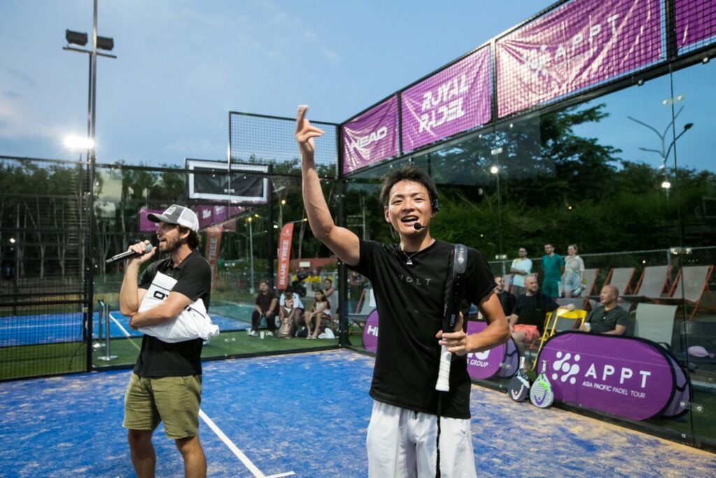 パデルコートでラケットを持ち、観客に向かって手を上げる五味亮将さん