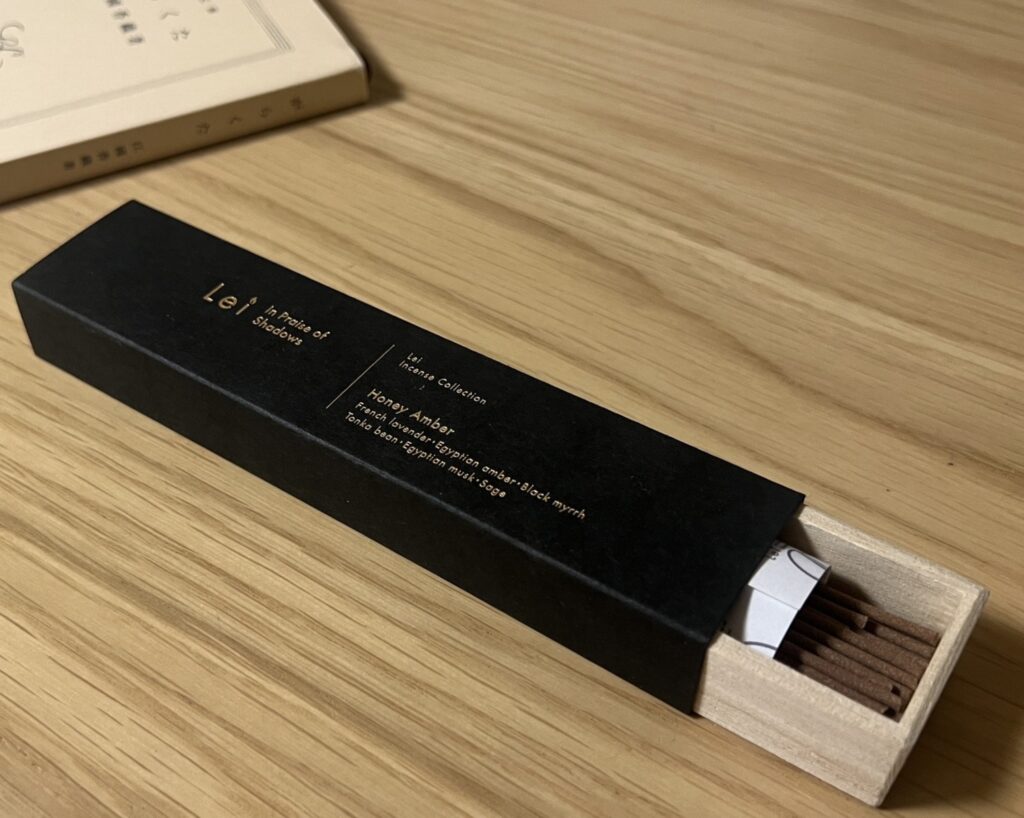 木のテーブルに置かれたLei Incense Collection（お香）の Honey Amber