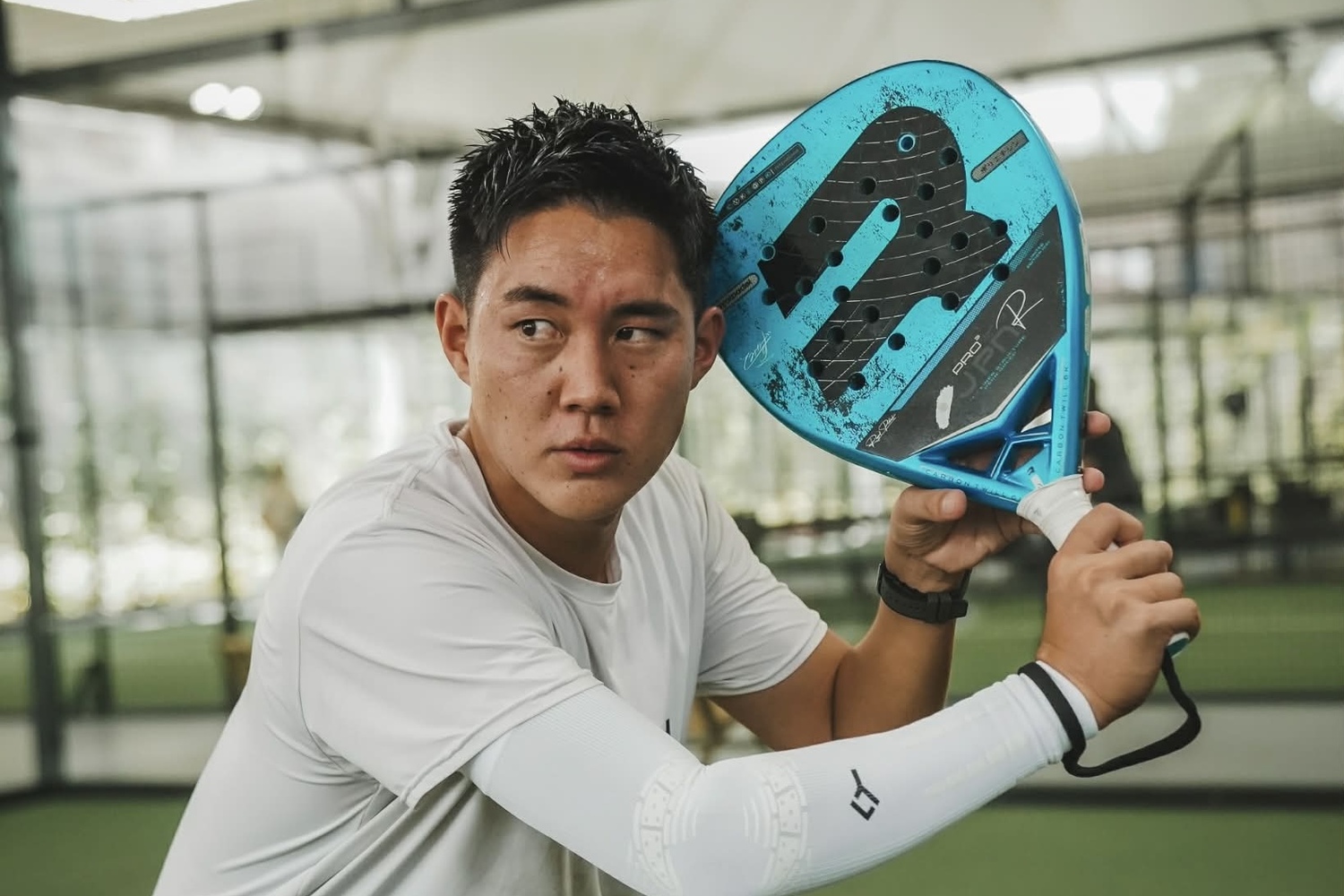 パデルコートでラケットを構え、横を見据える富田一輝選手