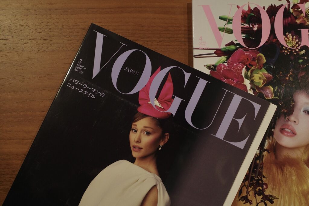 木のテーブルに置かれた『VOGUE JAPAN』2026年3月号と4月号