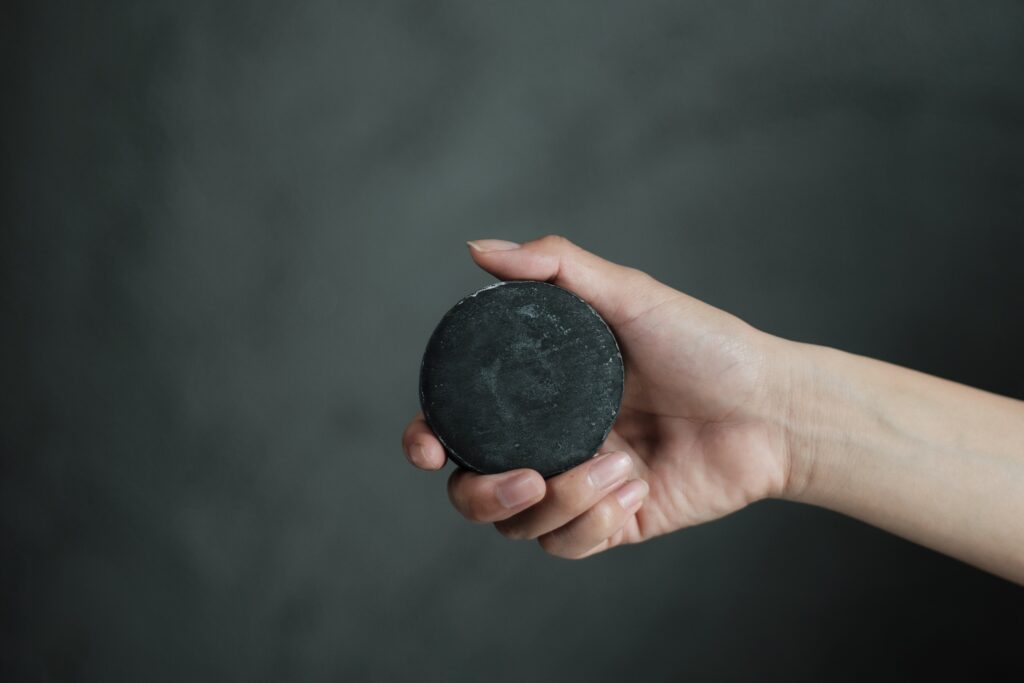 手に持ったBotanical Craft Soapの黒い石けん