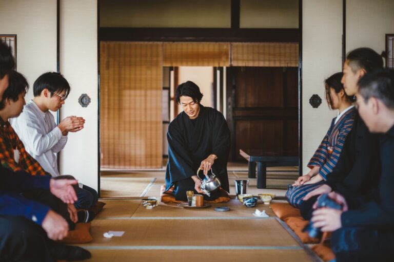畳の和室で、山田翔太さんが参加者を前に茶を点てているみたて茶会の風景