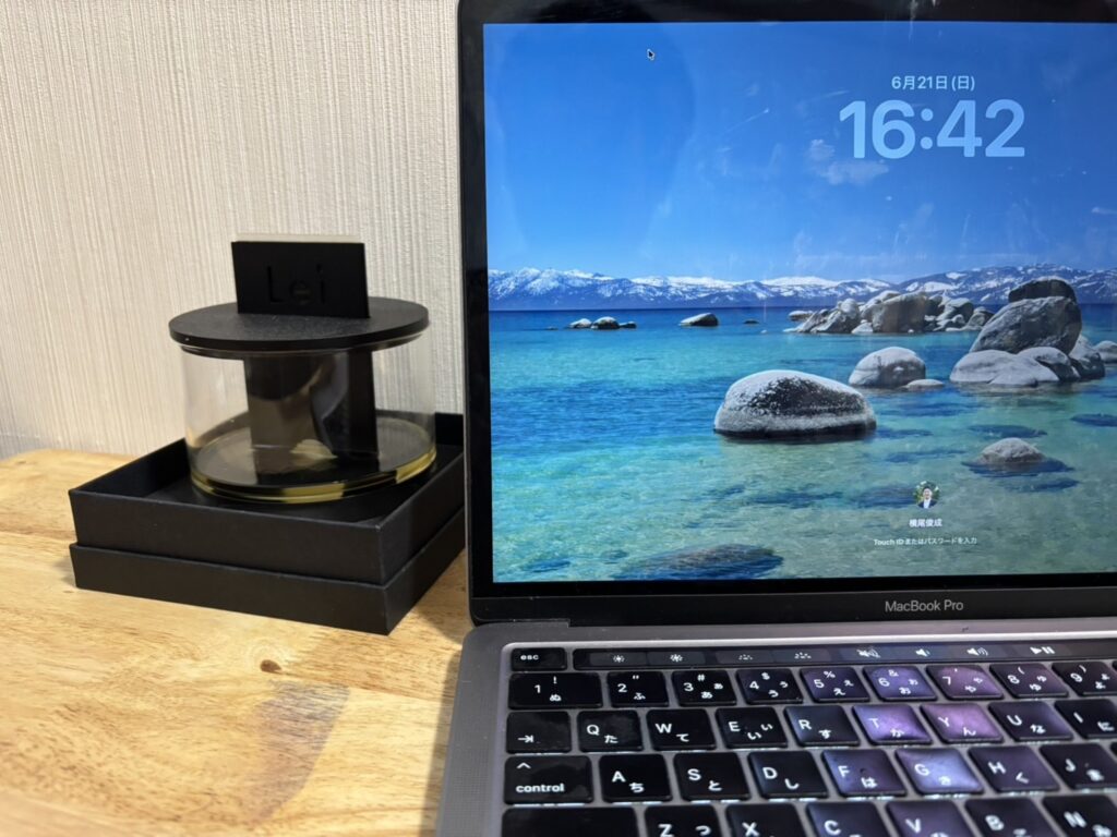 木製のデスクの上に、Lei card diffuserとノートパソコンが並んで置かれている様子。