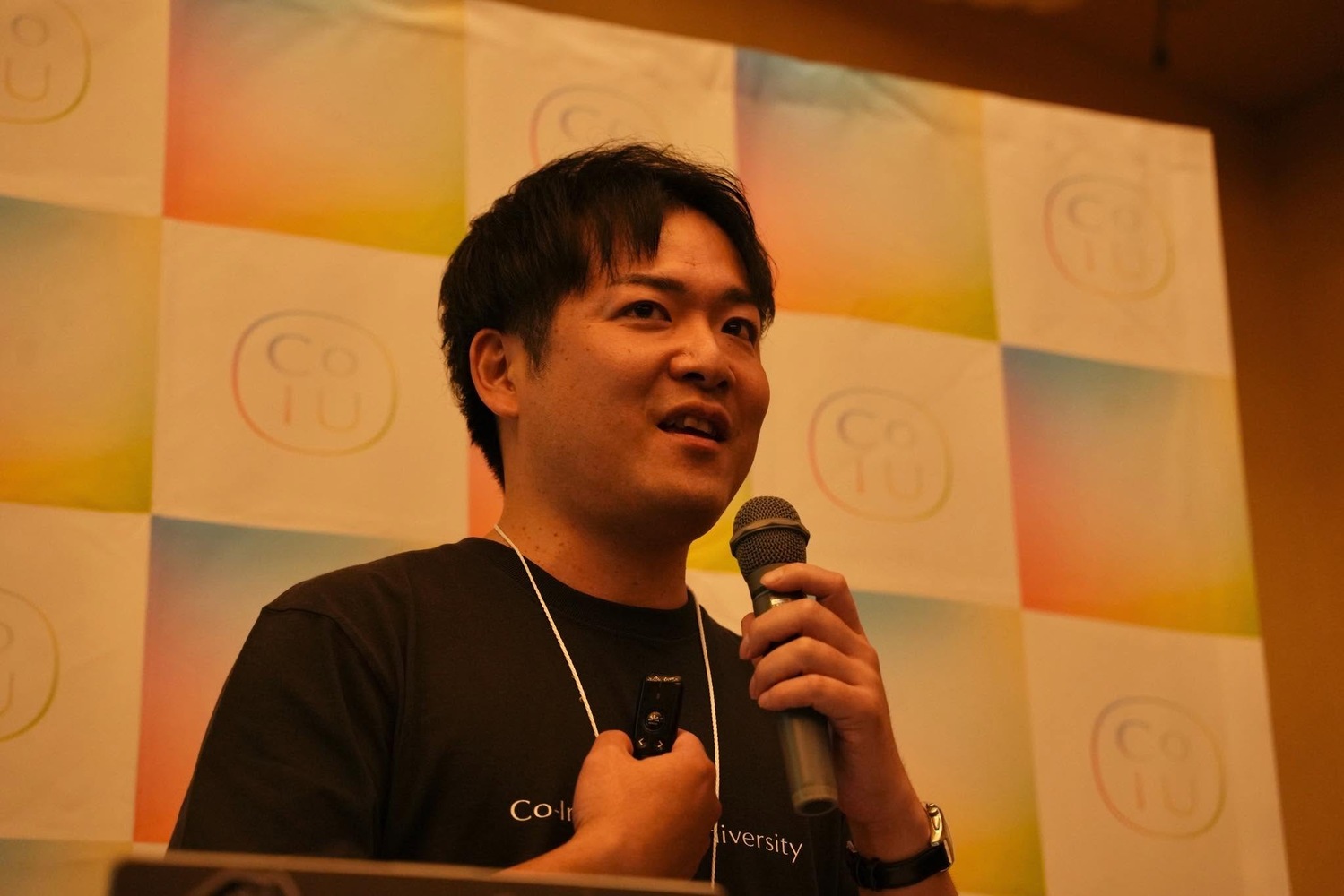マイクを持ち、地方創生や社会を動かす仕組みについて登壇する横尾俊成さん。