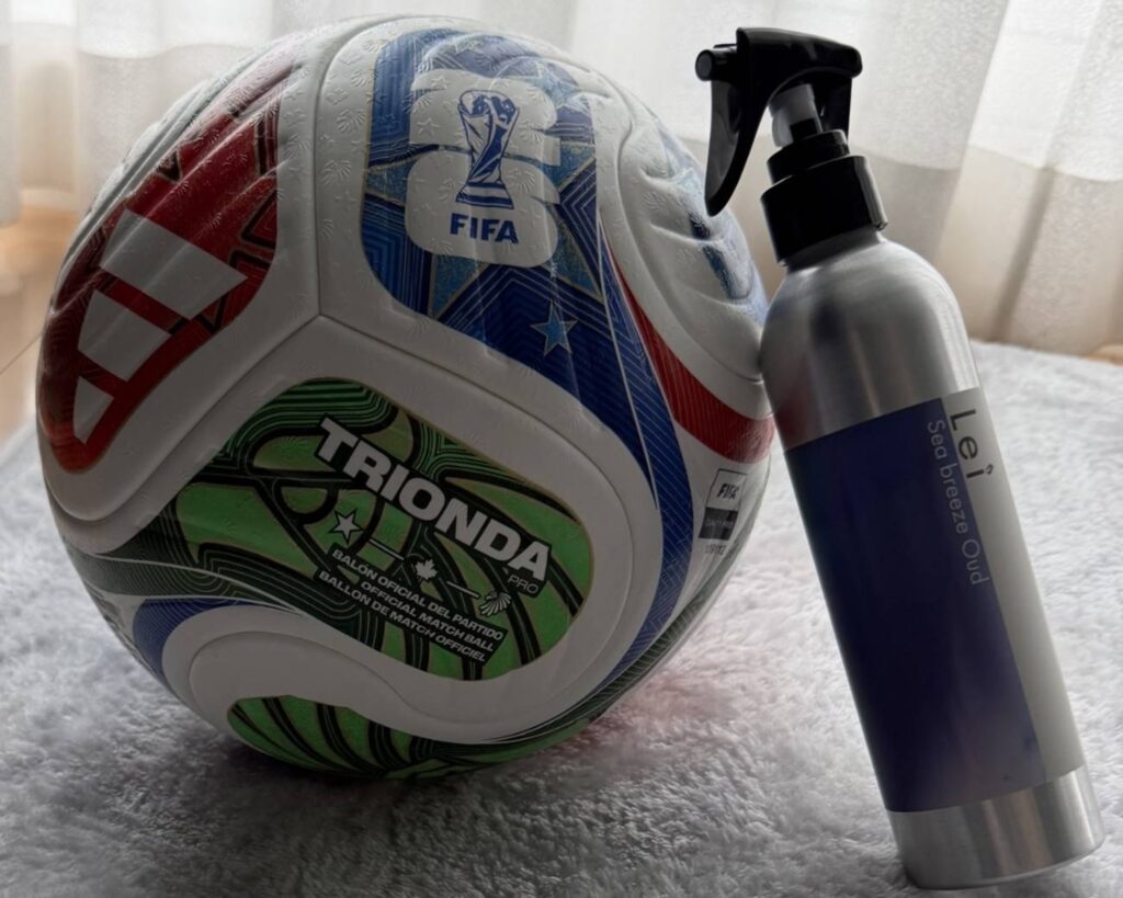 サッカーボールの横に置かれたLei Room Spray