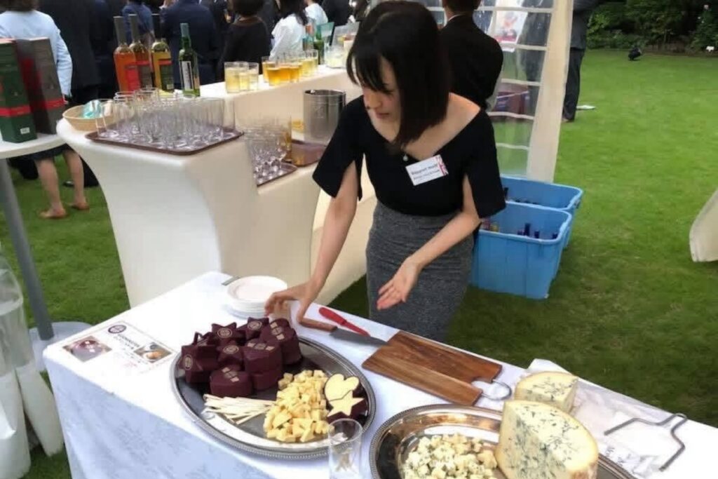 屋外イベントでチーズを並べ、来場者に提供する準備をするオーガニックインポーターの真衣さん