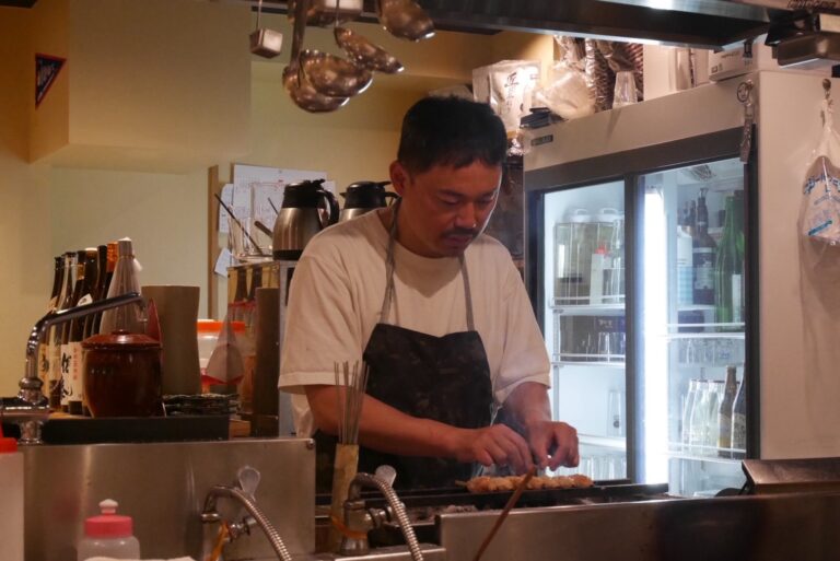 飲食店「吉」の厨房で焼き鳥を焼くオーナーの小峰丈晴さん