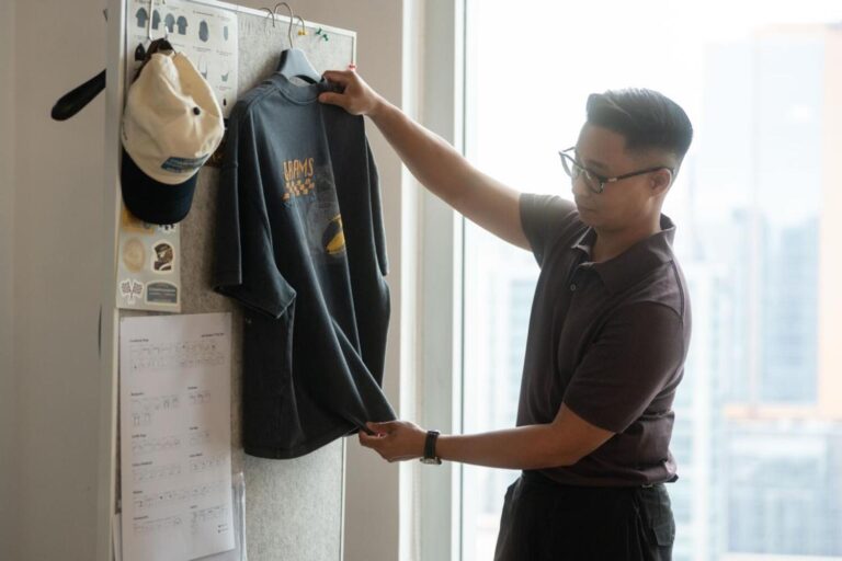GRAMS28のワークスペースでTシャツを手に取るベンジャミン・チャンさん